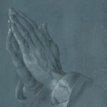 Manos juntas en oración